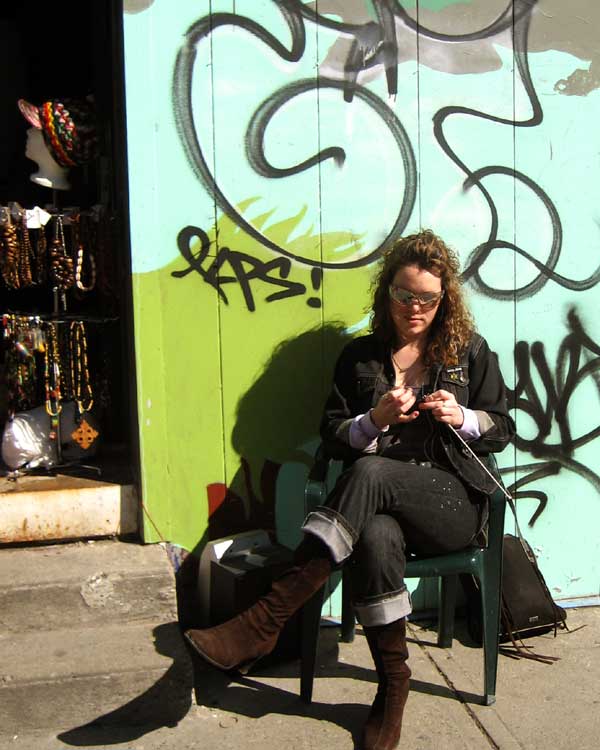 Knitting Her Wares in the Sun